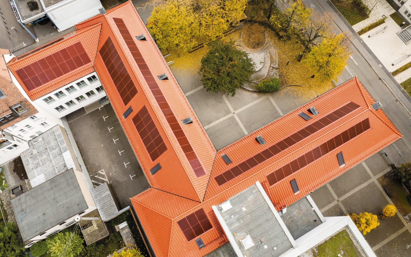 Budynek z dachem z dachówki i czerwonymi panelami fotowoltaicznymi X-Frame