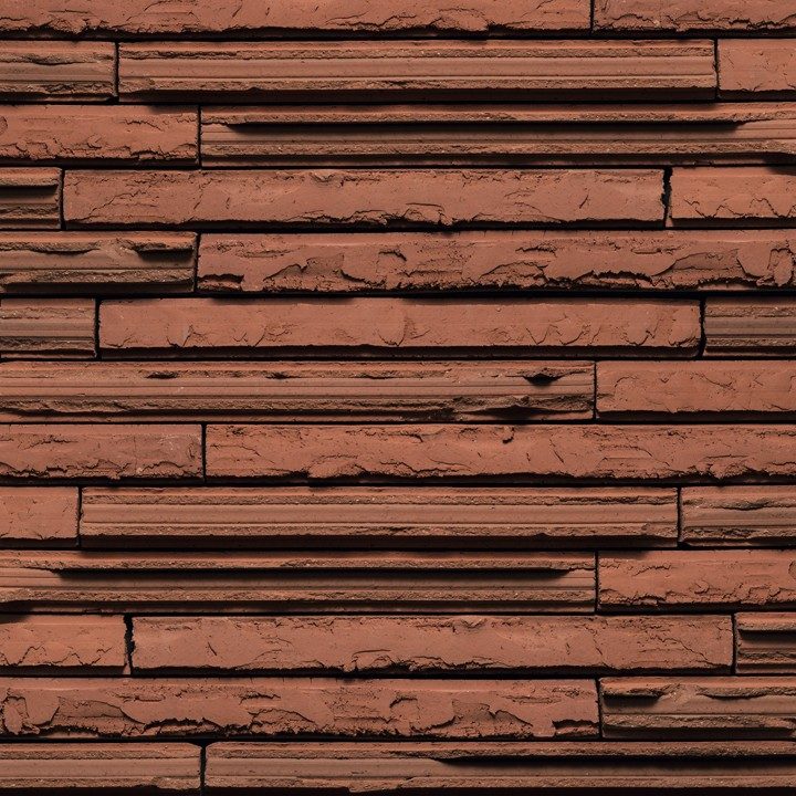 Tekstura cegieł i płytek klinkierowych Terca Cassia Long Red. Produkt o nietypowym wydłużonym formacie, który z łamaną fakturą lica tworzy wyjątkowe możliwości kształtowania elewacji. Kolor czerwony.